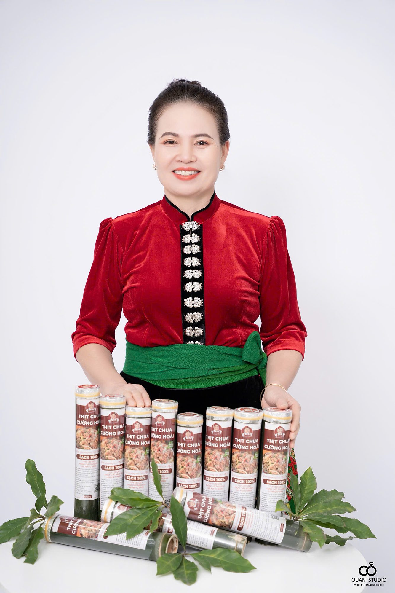 Bà Phan Thị Hoài trong trang phục Thái bên các ống thịt chua Cường Hoài